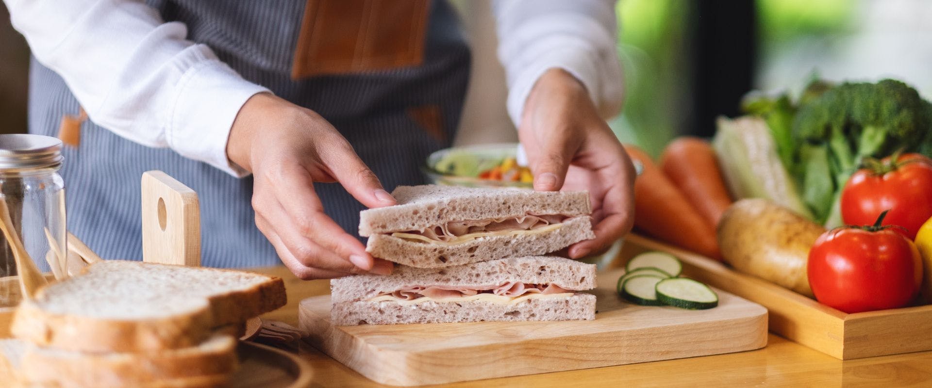 Person assembling ham sandwich