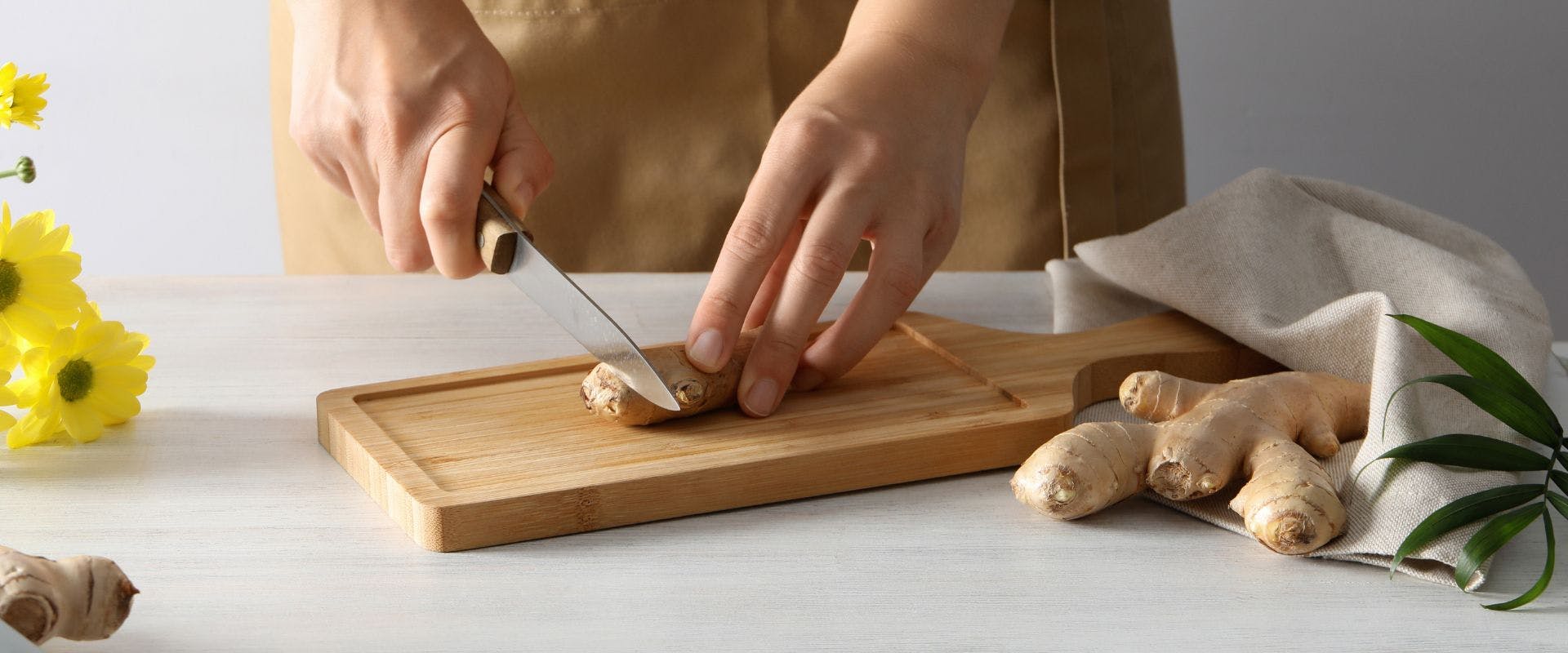 Ginger being sliced on a wooden board