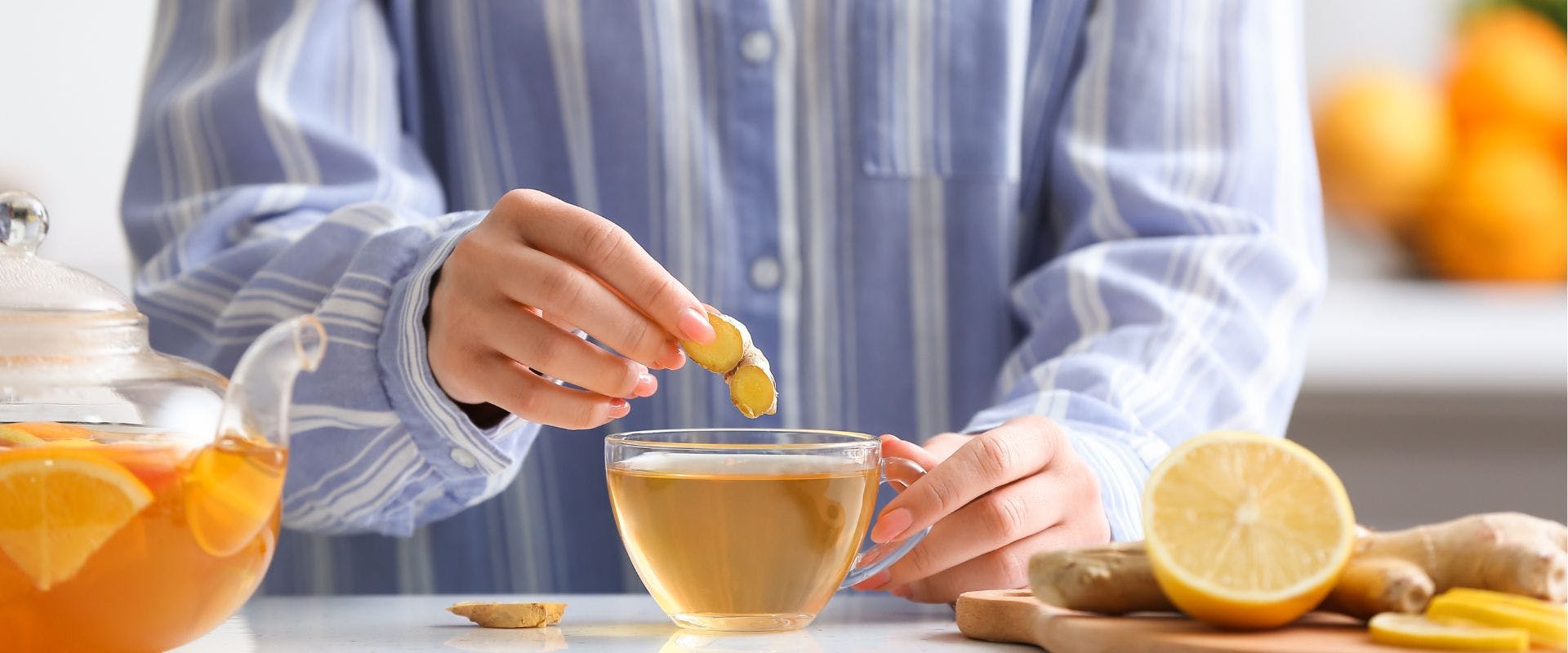 Person putting ginger in tea