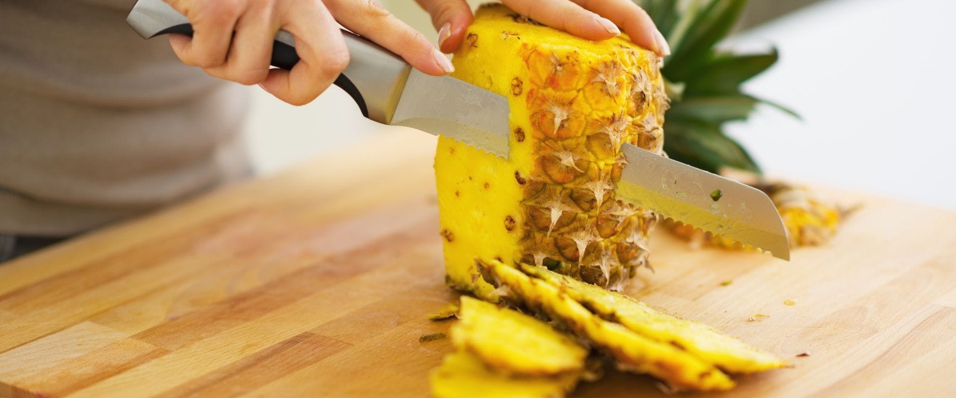 Person slicing pineapple