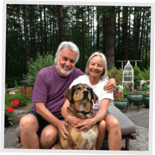 A man and a woman hugging a dog