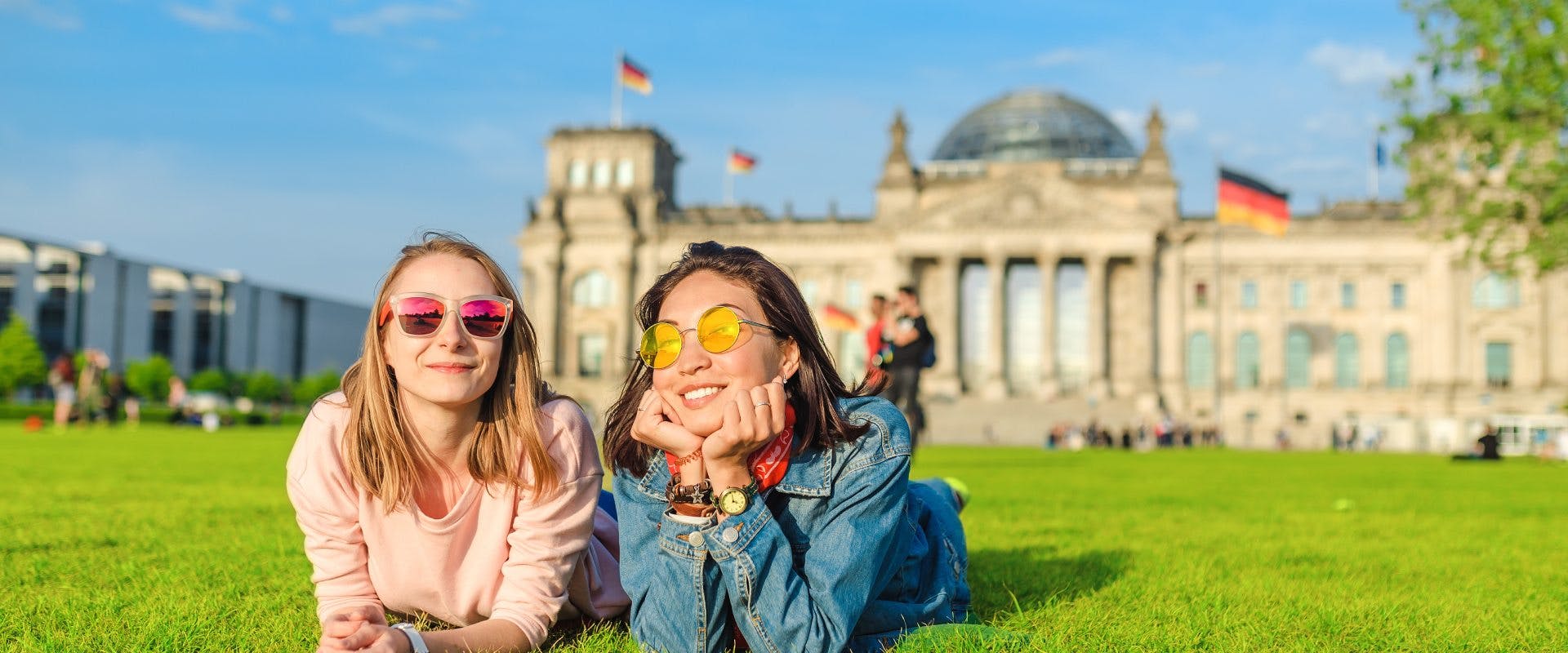Two solo female travelers enjoying the sun outside the Reichstag Building.