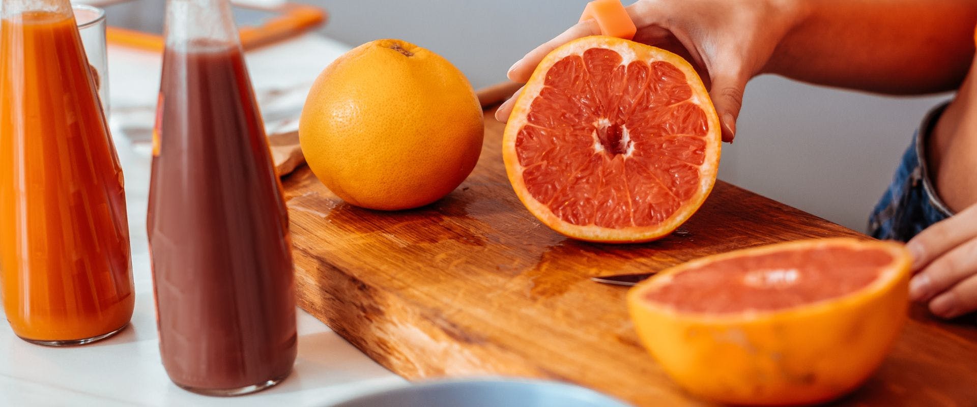 Halved grapefruit on wooden chopping board