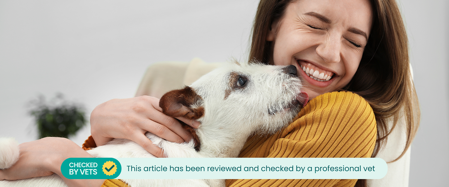 A woman smelling her puppy's breath. This article has been reviewed by a professional vet