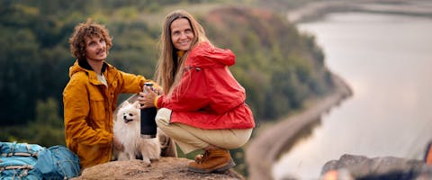 Couple with pet dog enjoying hiking trip