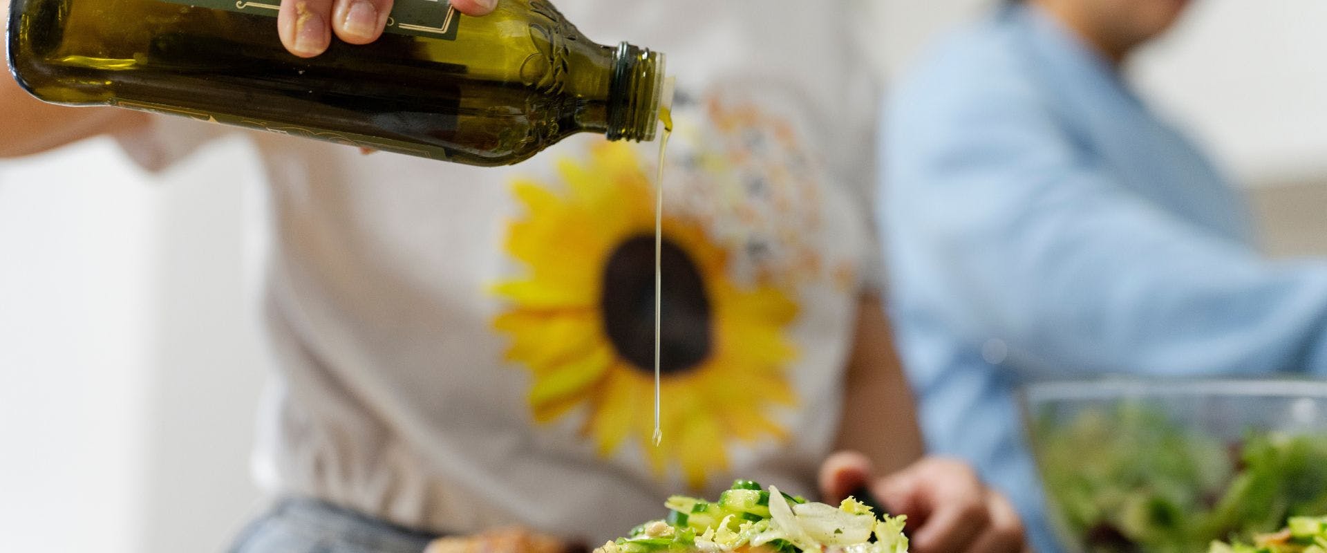 Olive oil being poured onto salad