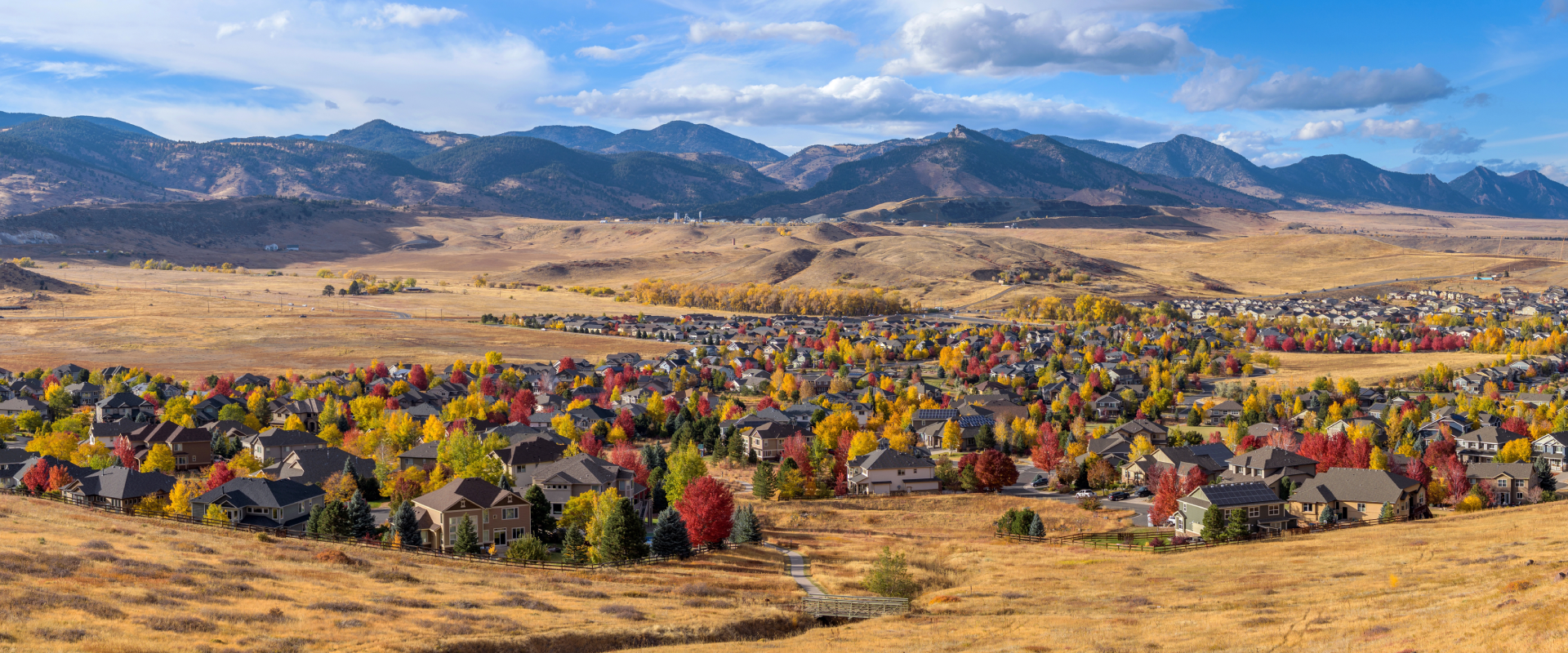 a wide-shot view of Arvada skyline with multi-colored trees and surrounding desert and mountains