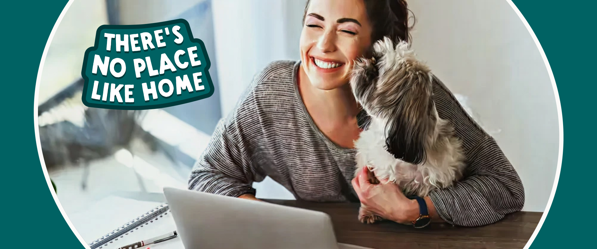 A person working from a laptop with a dog