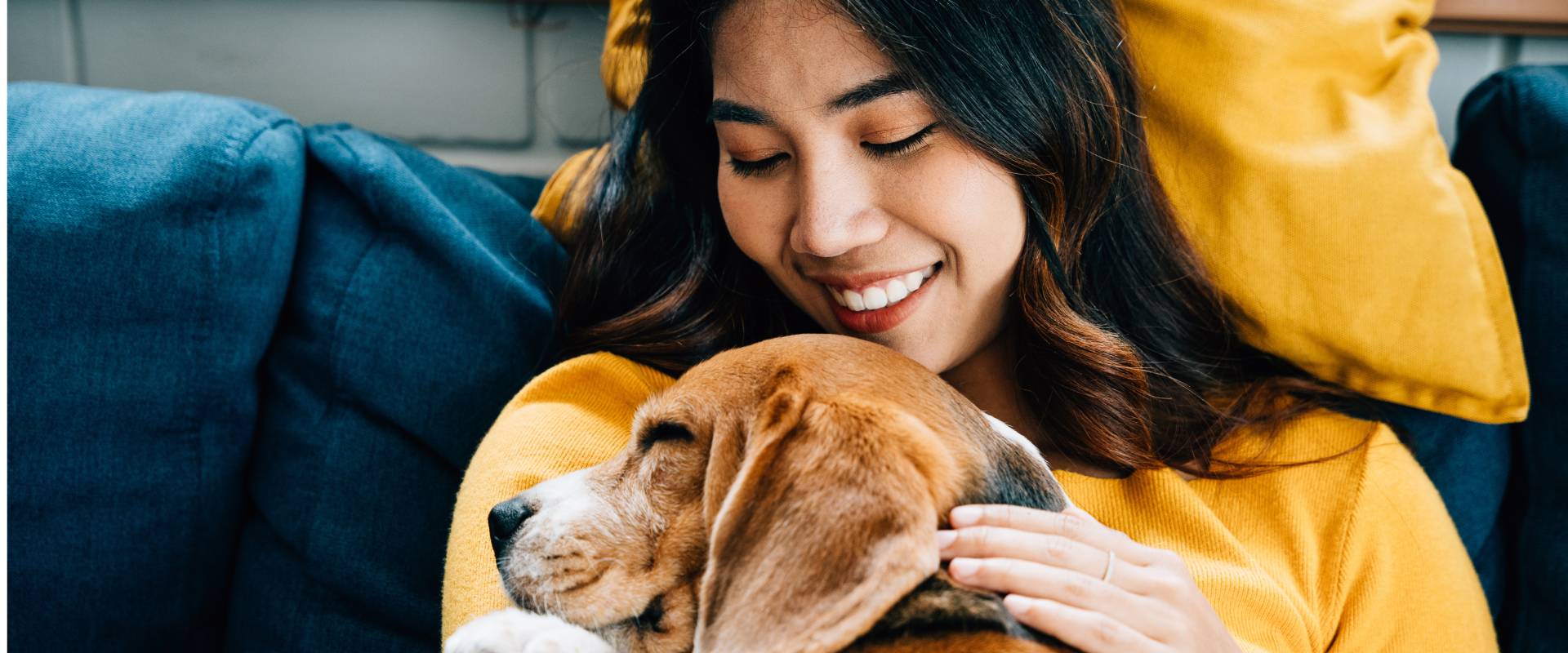 Woman with her hand on a large dog laying on her asleep
