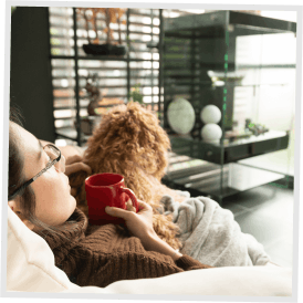 A woman on a sofa with puppy