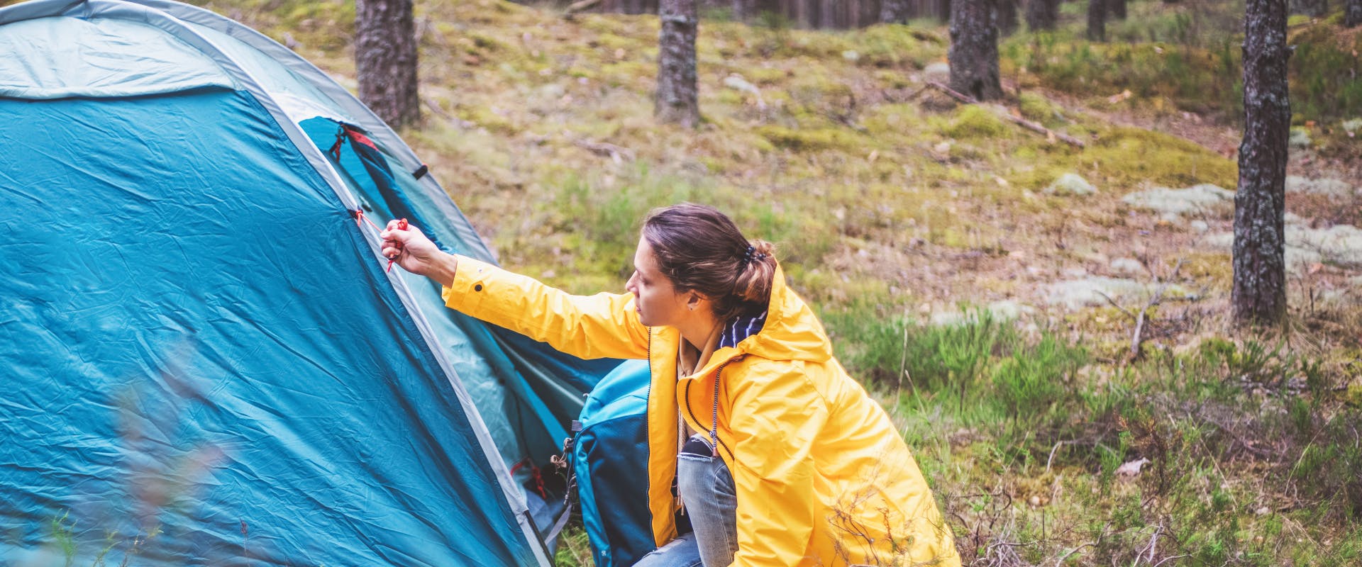 solo female traveler zipping up her solo camping tent