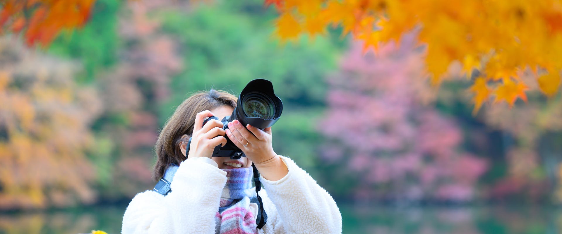 solo female traveler photographing autumn leaves in Japan