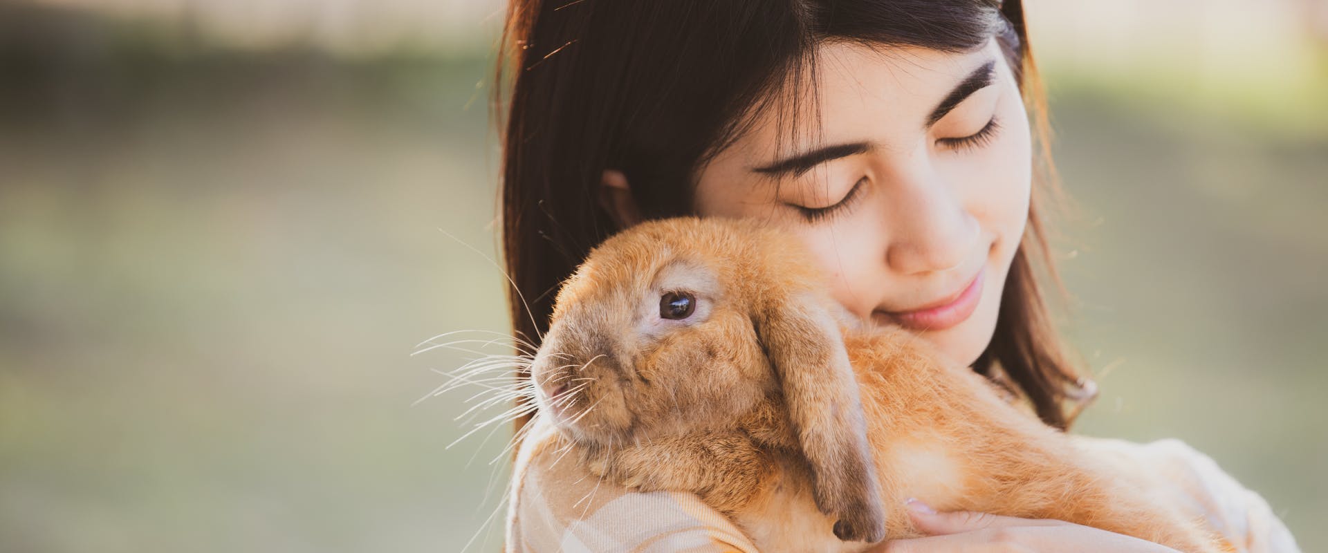 A woman hugs a rabbit.