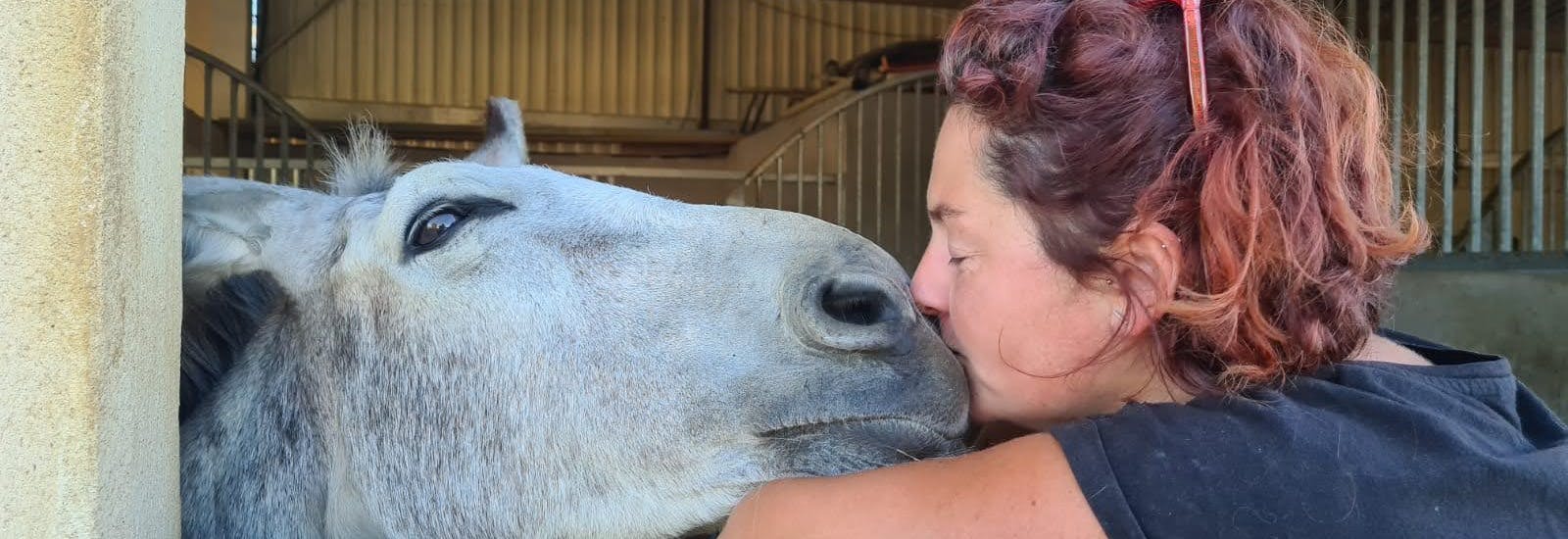 Woman hissing a horse on the nose