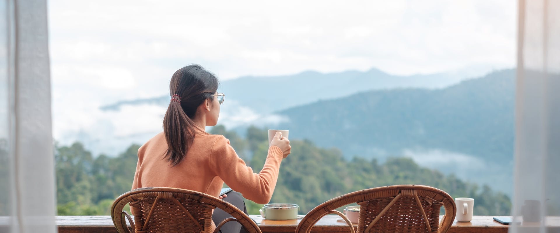 A woman enjoys a coffee with a view.