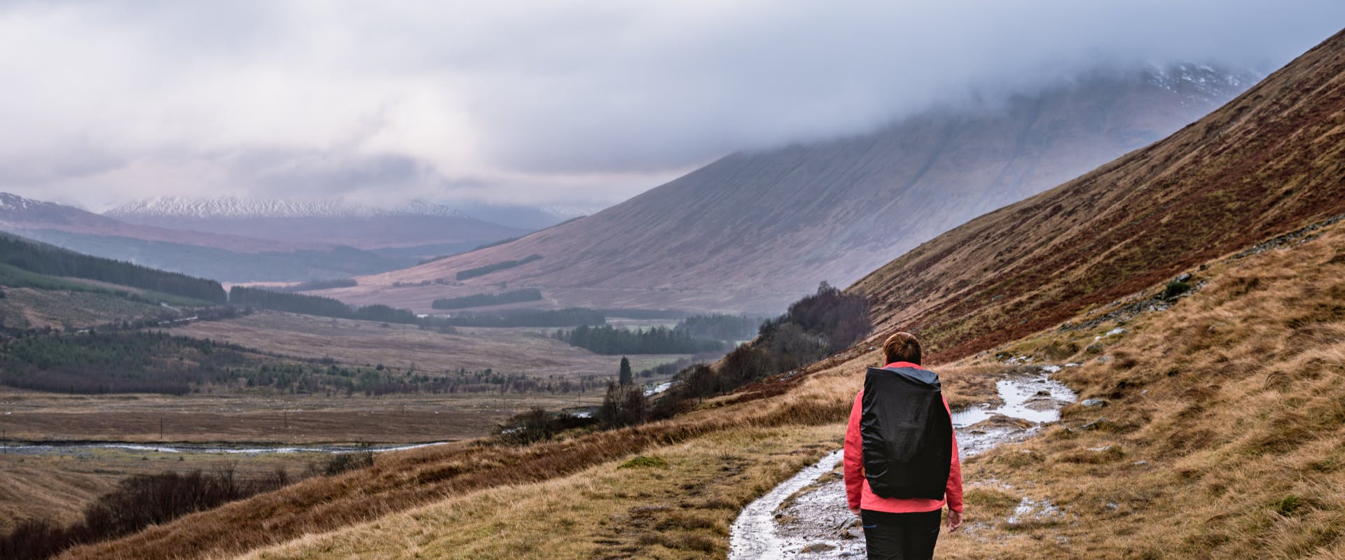 a solo female traveler hiking through the scottish highlands