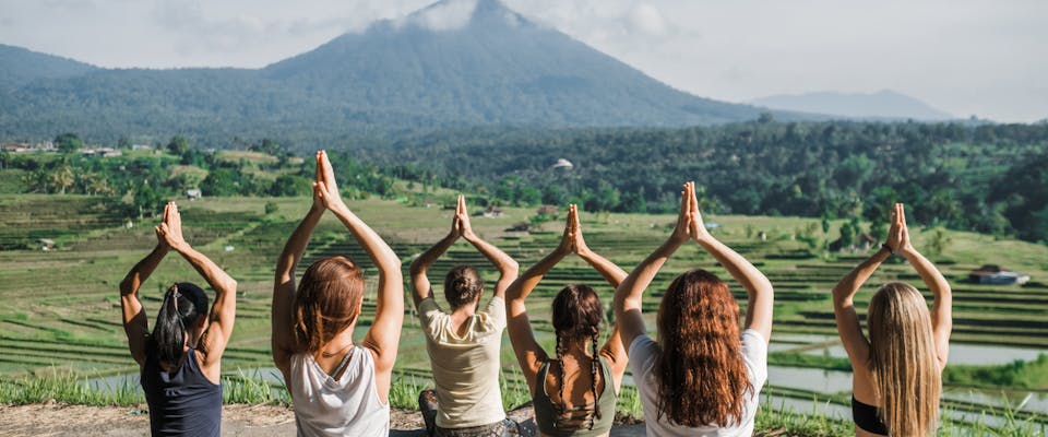 a group of solo female travelers taking a yoga class outside