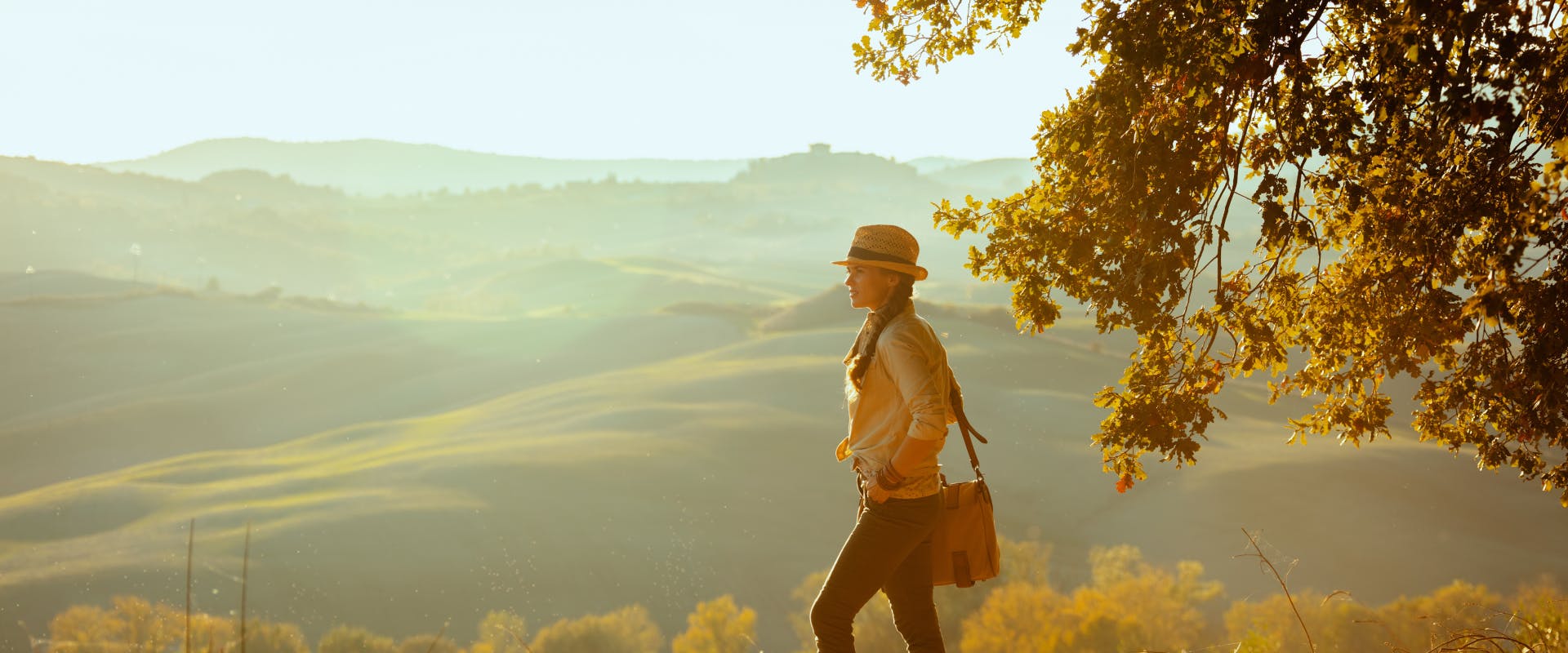 A woman walks through the hills of Tuscany.
