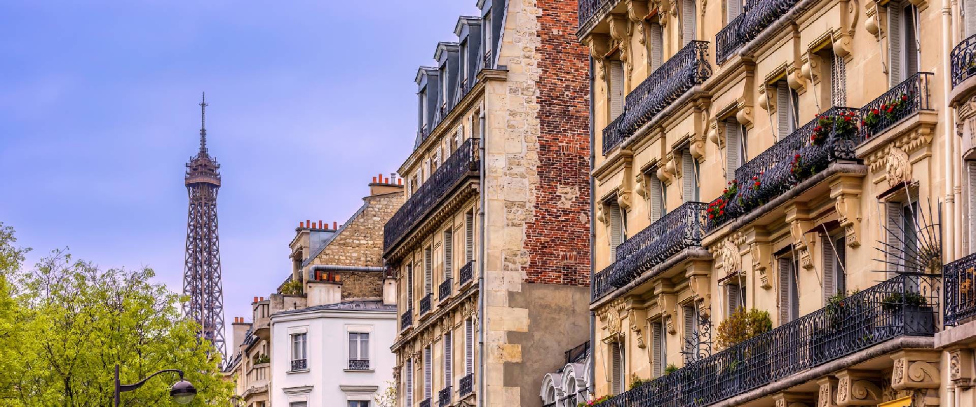 Traditional Parisian residential facades with the top of the Eiffel tower in the background