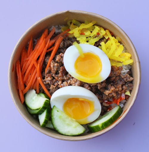 Image of rice bowl with eggs, carrots, cucumbers and more