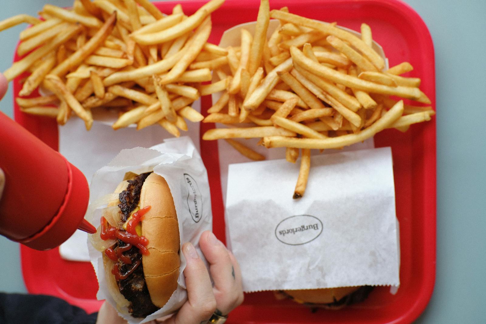 Image of a vegan cheeseburger and french fries on a red tray