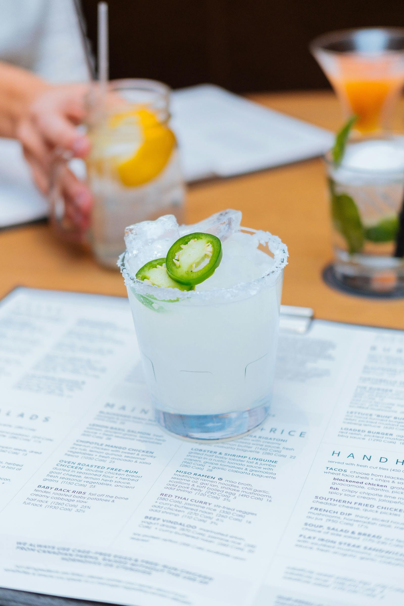 Cocktail placed on top of a menu at a restaurant. 