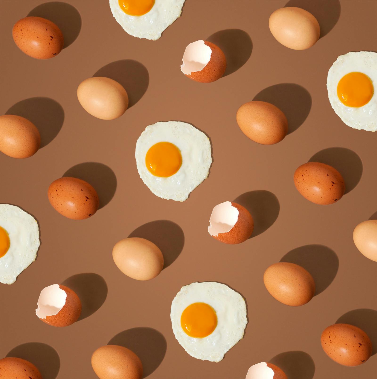 Patterned image of eggs and eggs over easy on brown background