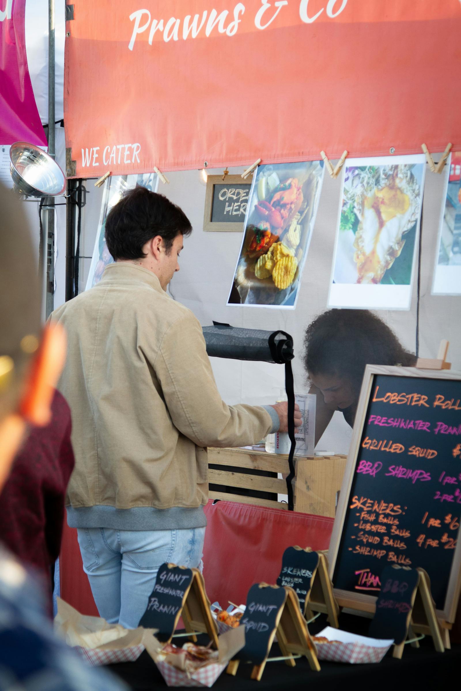 Image of a customer picking up an order from a seafood food truck.