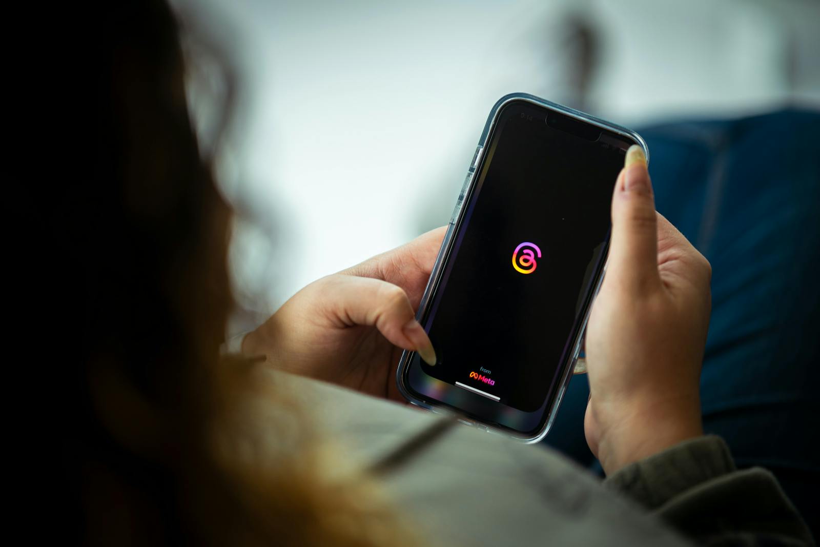 Woman looking at the Threads app on her phone.