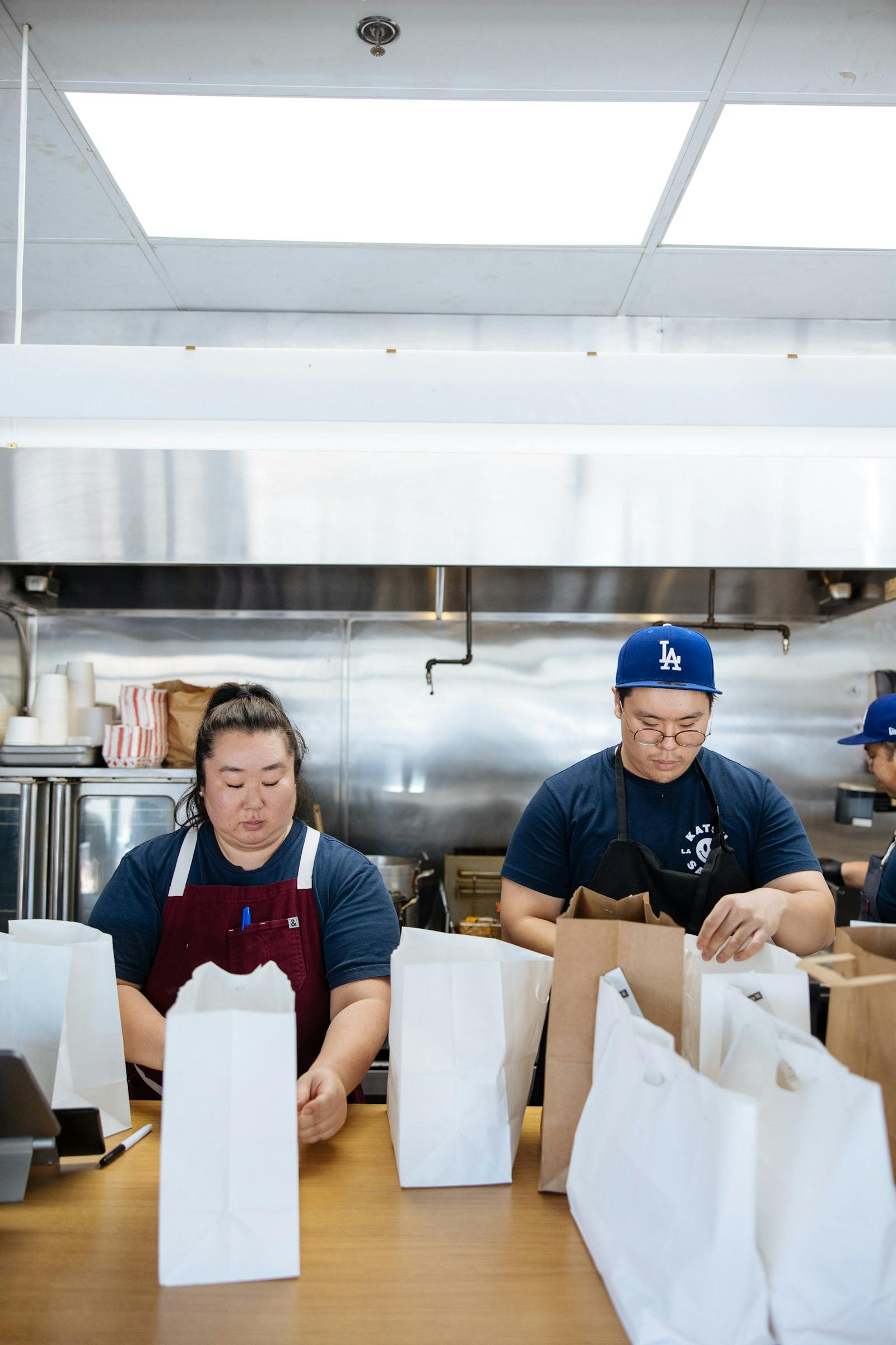 Image of two restaurant employees packing delivery orders
