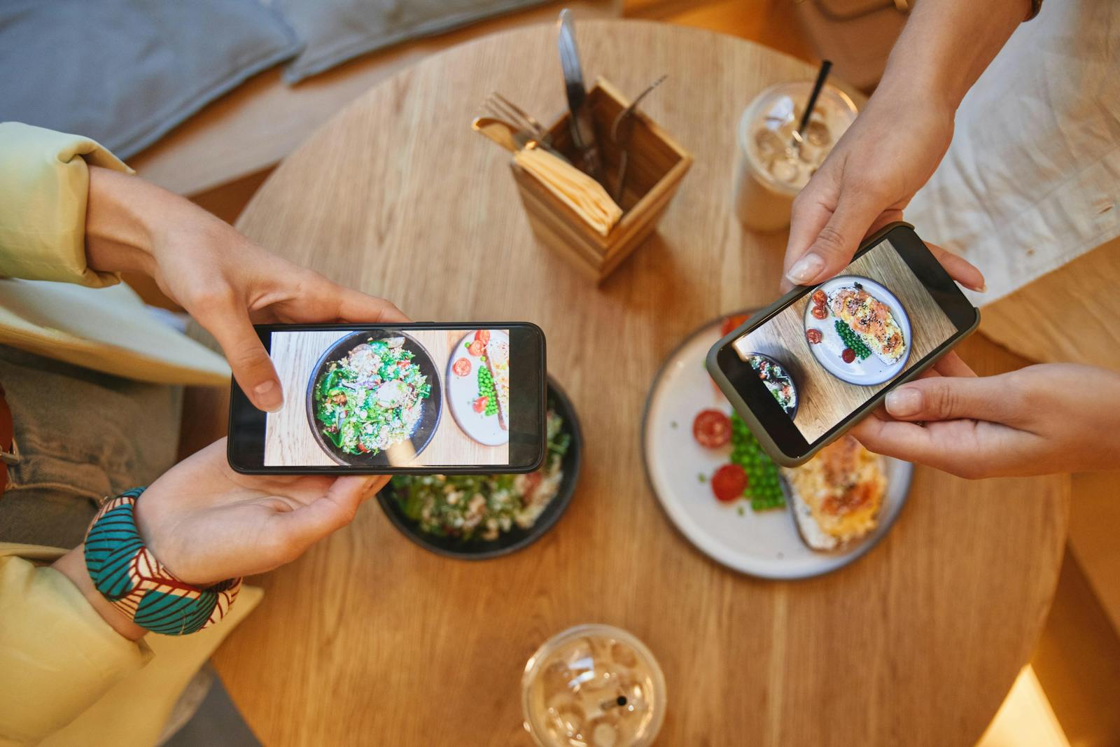 Influencers taking photos of food at a restaurant. 