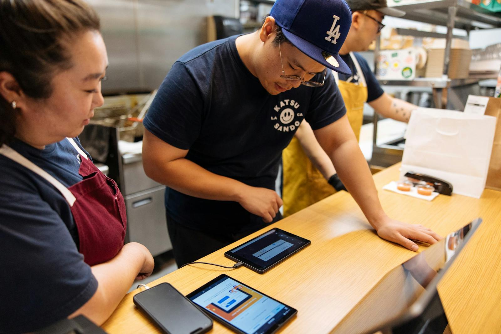 Image of restaurant employees managing incoming orders on tablets