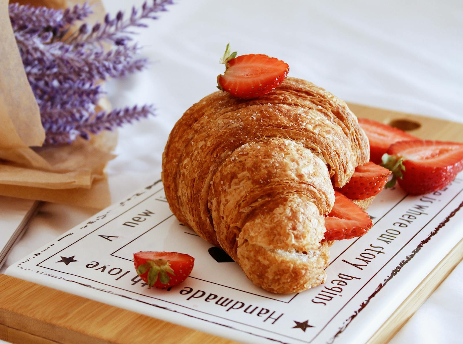 A croissant dressed with some strawberries. 