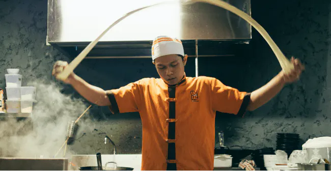 Image of restaurant worker making bang bang noodles