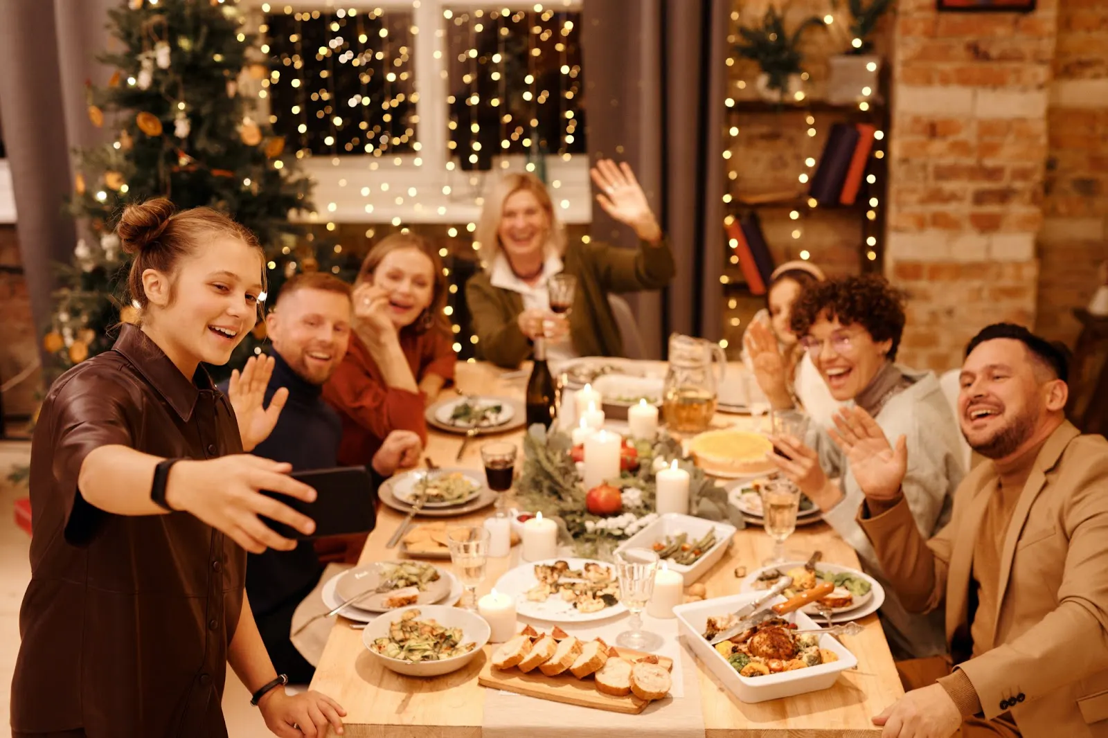 Image of a group of friends taking a selfie while celebrating the holidays at a restaurant