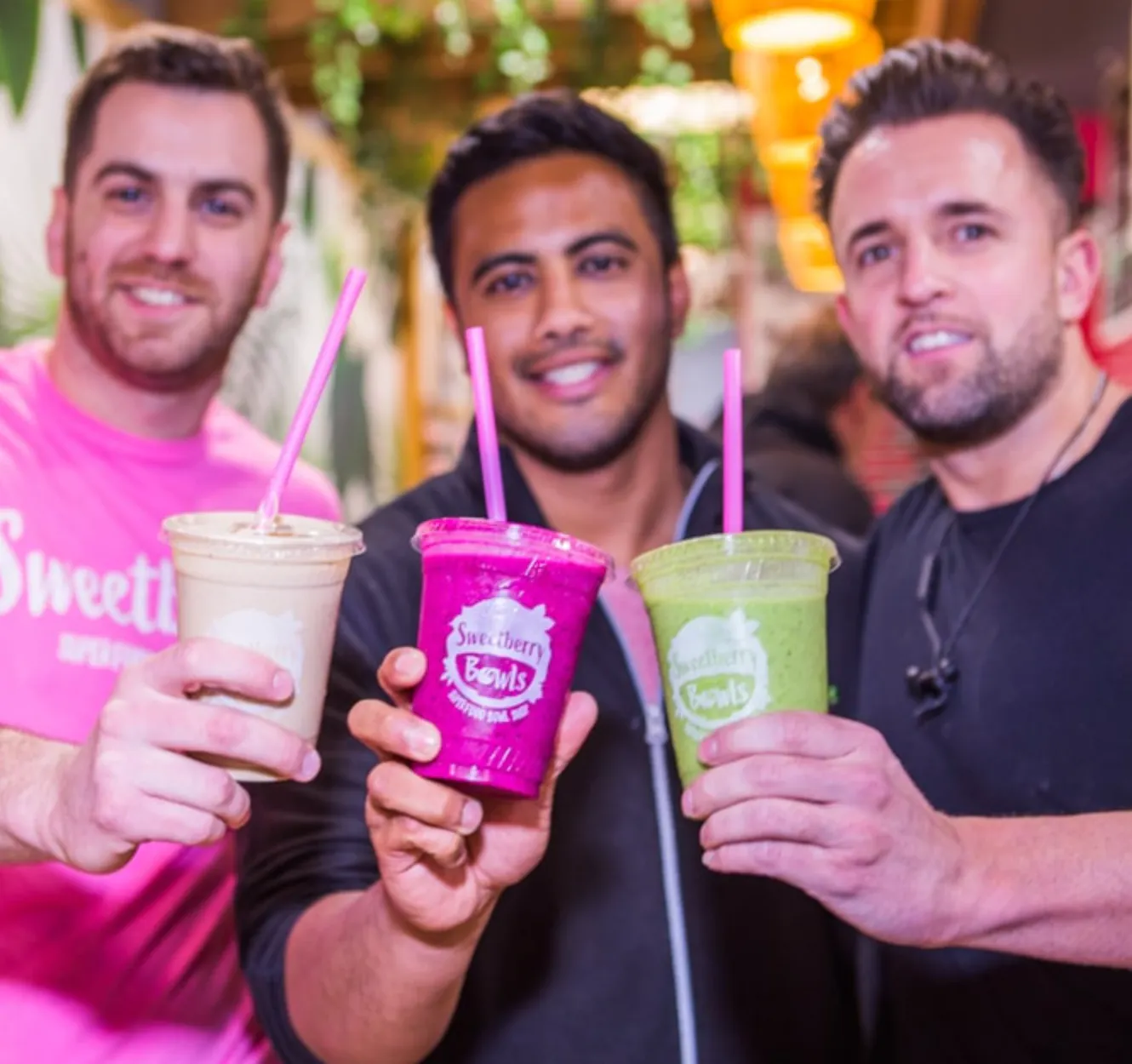 Image of Desi Saran and two other Sweetberry employees cheersing their smoothies