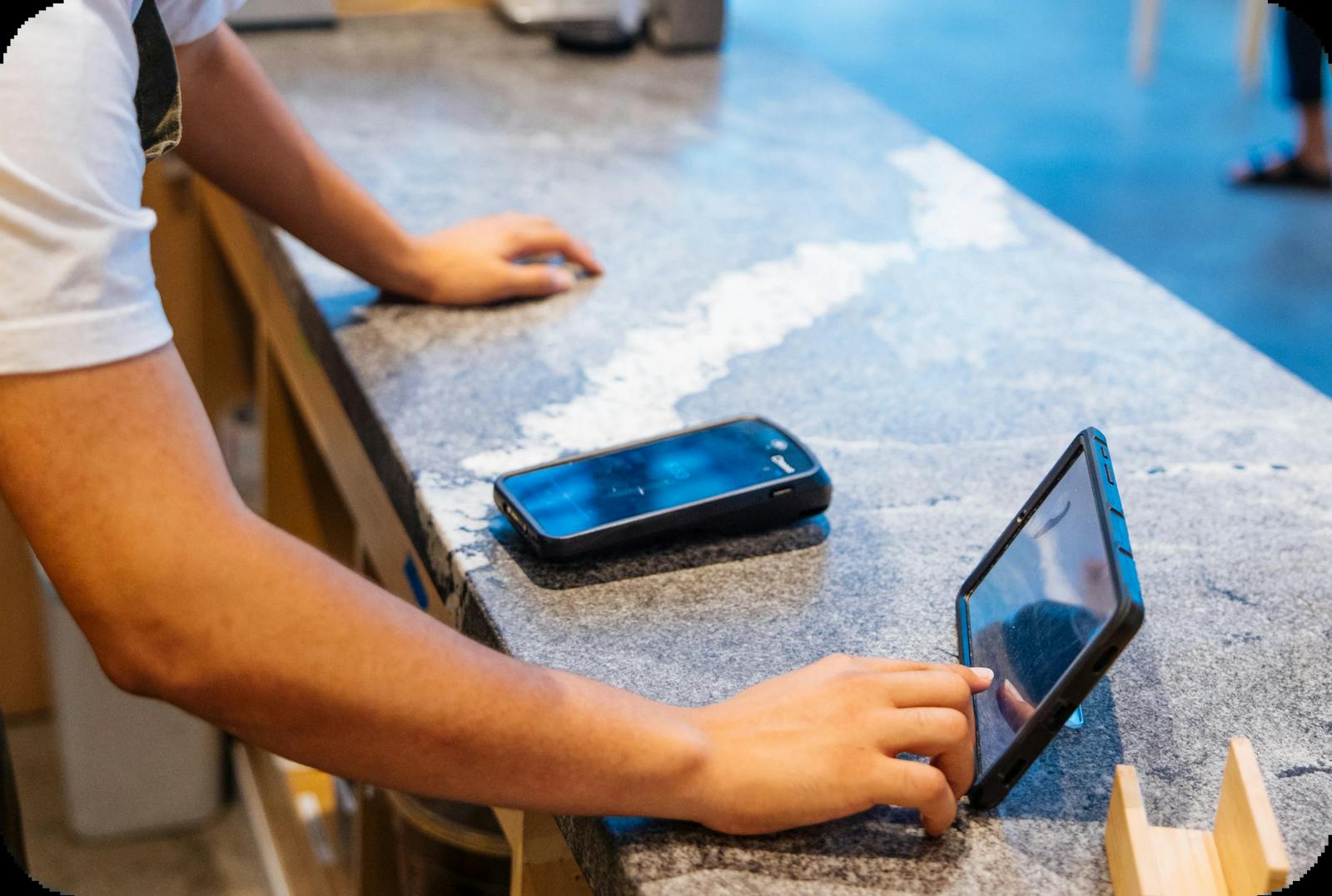 Image of a restaurant staff using a tablet at the counter