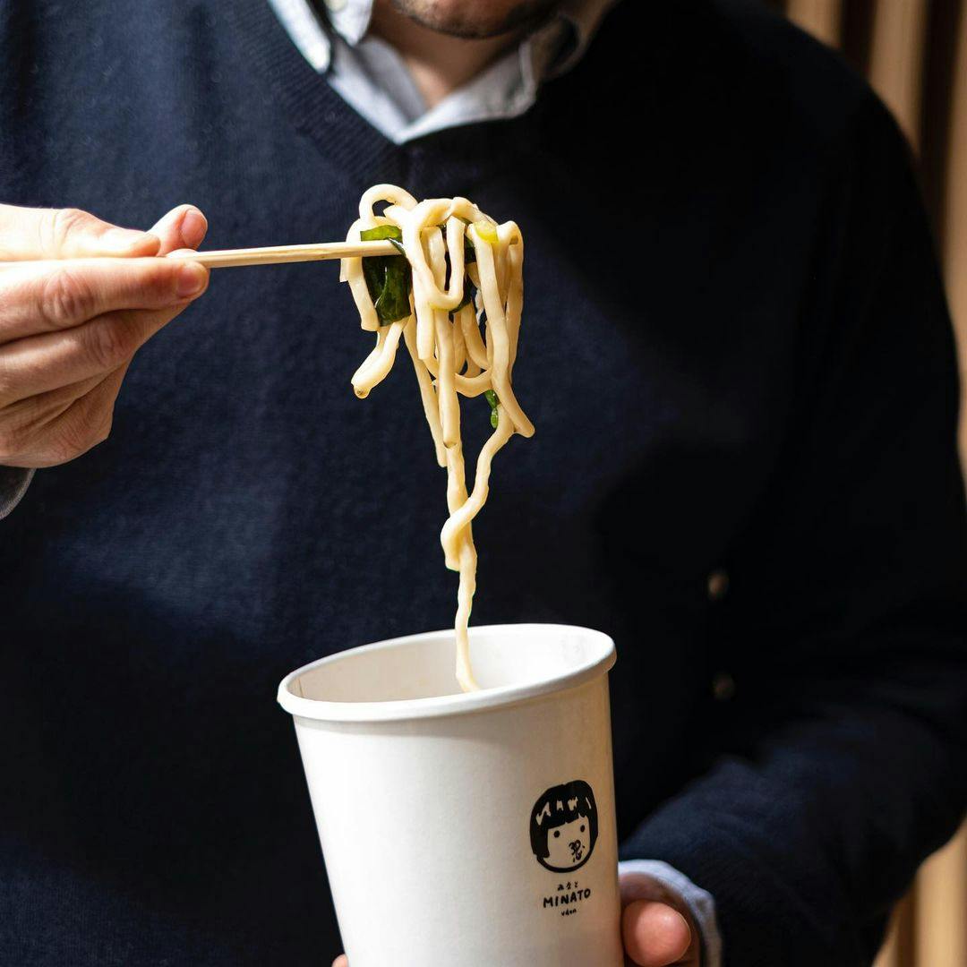 Image of someone eating ramen from a cup