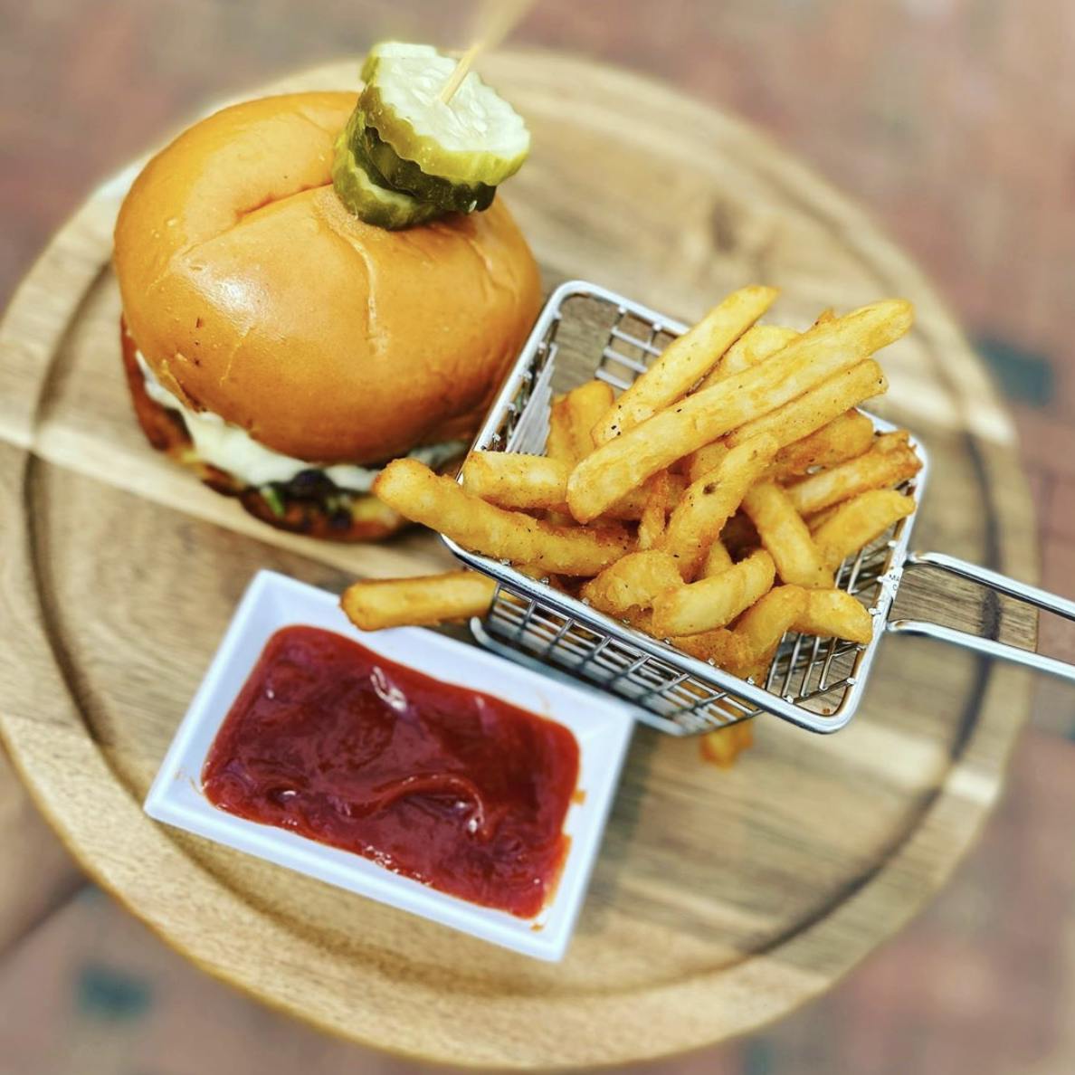 Image of a B-Unos burger, fries, and a side of ketchup