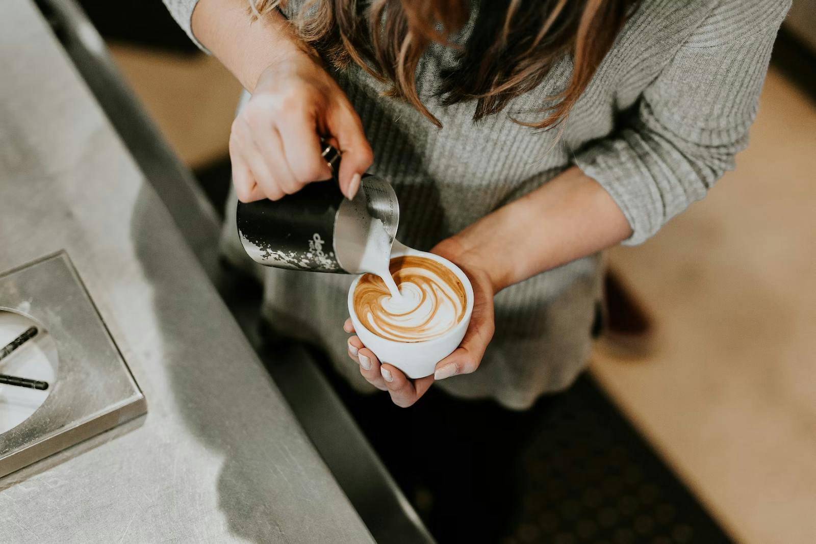 Image of a barista pouring latte art