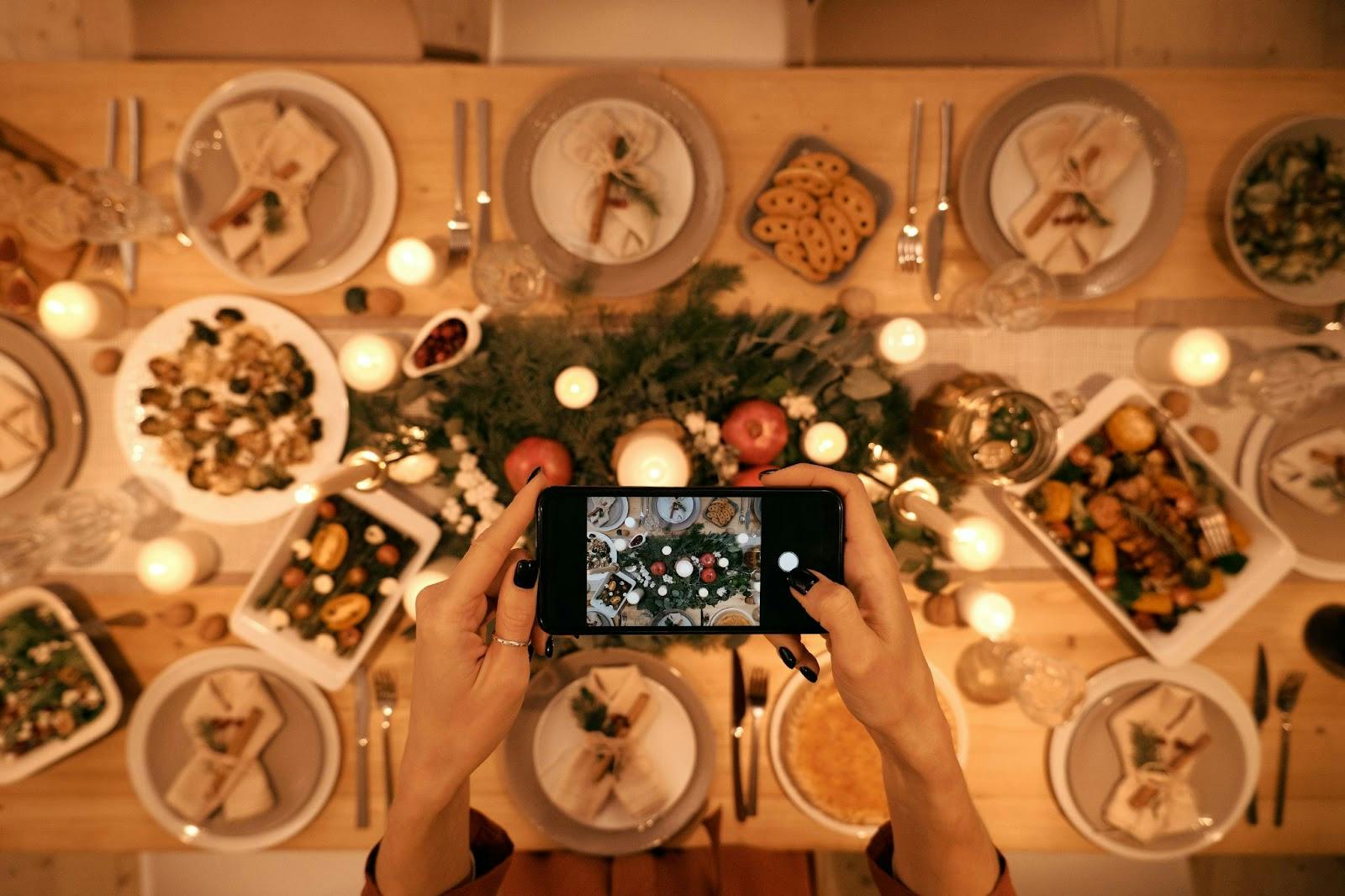 Using a mobile phone camera to capture a photo of a holiday dinner spread