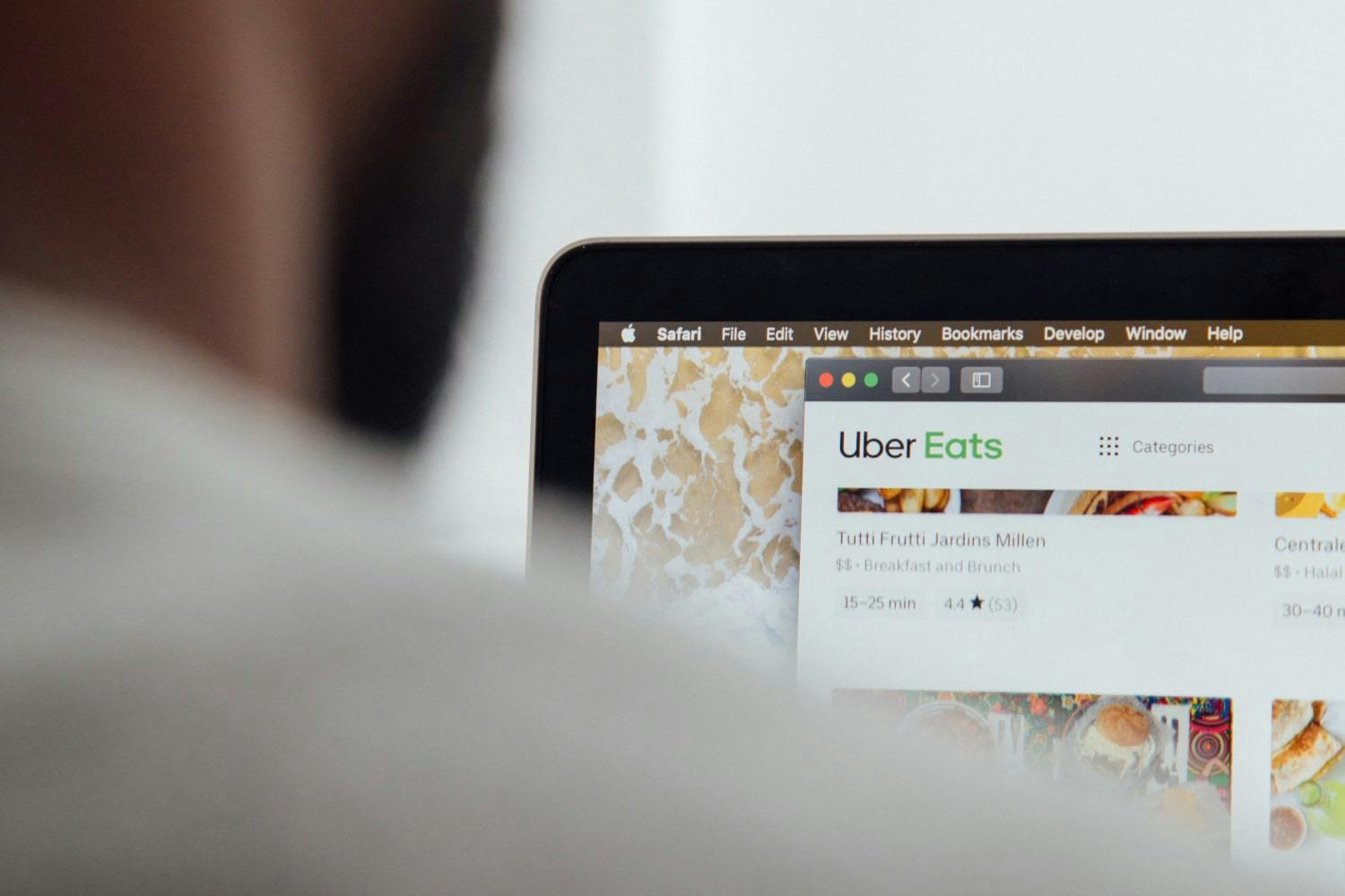 Image of a person looking at a laptop screen with the Uber Eats website open