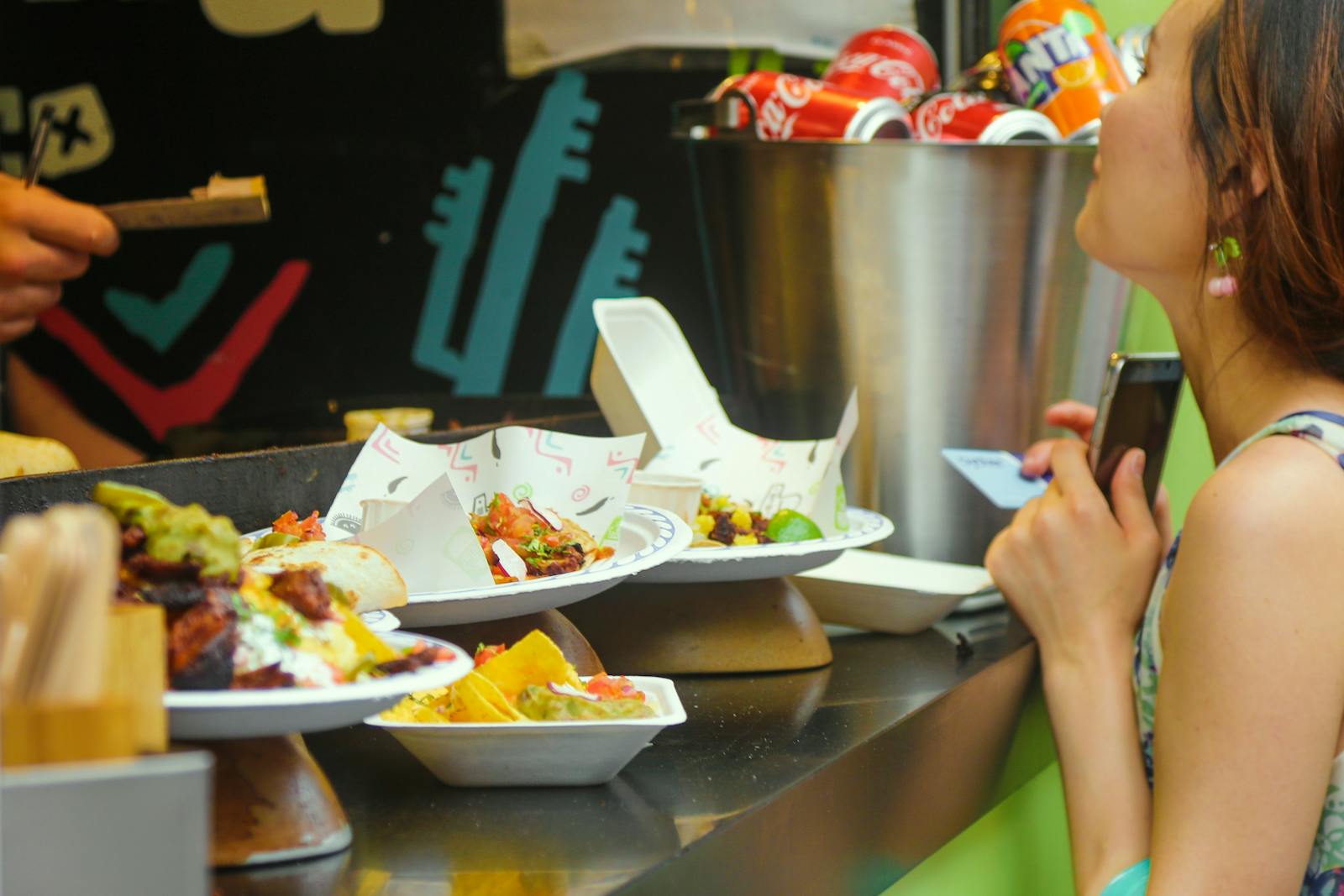 Image of a woman picking up her food from the counter at a restaurant