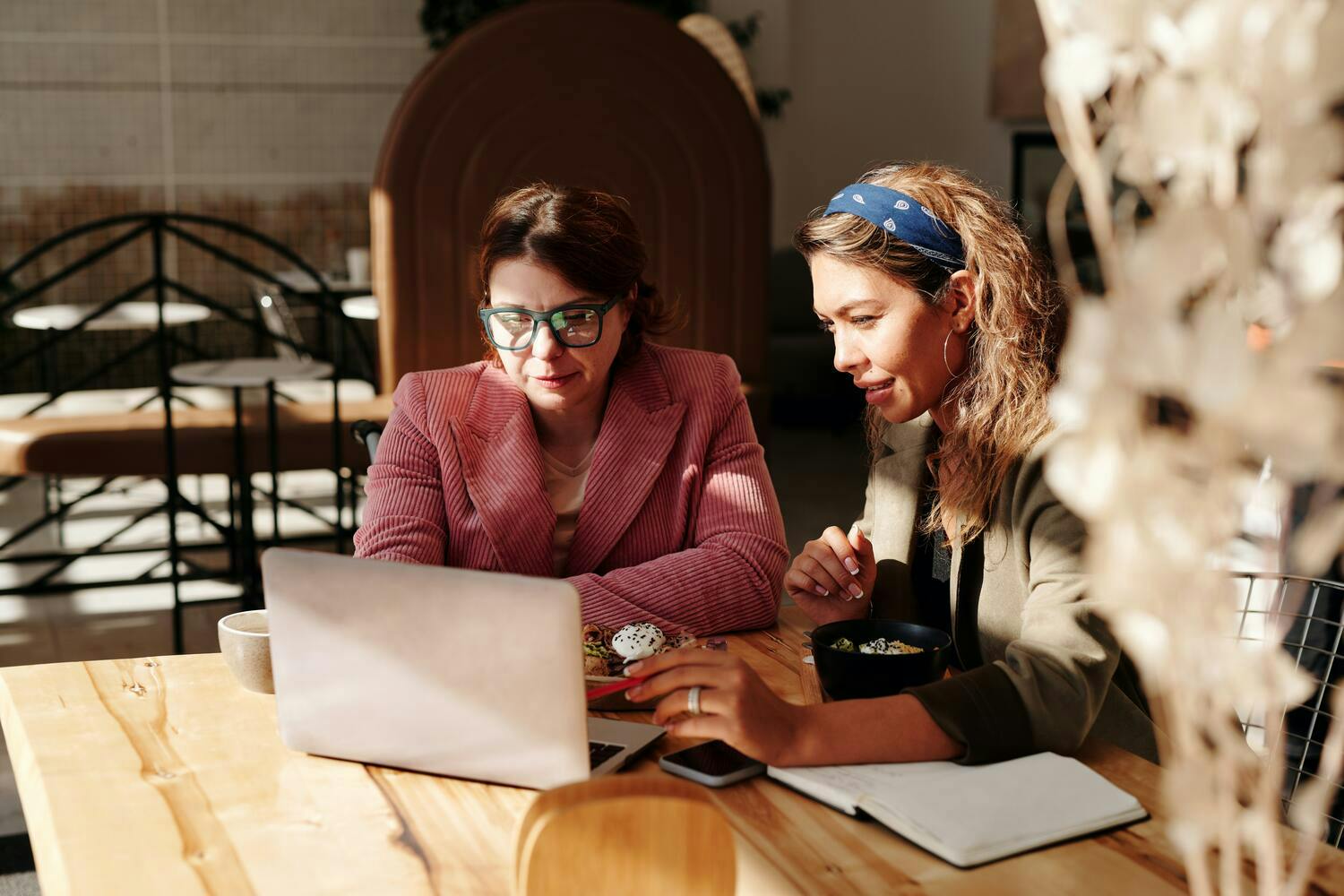 Image of two women working in front of a computer