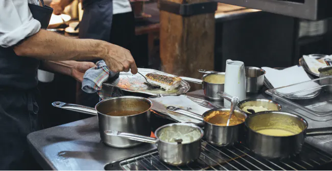 Image of a restaurant employee preparing food in the kitchen