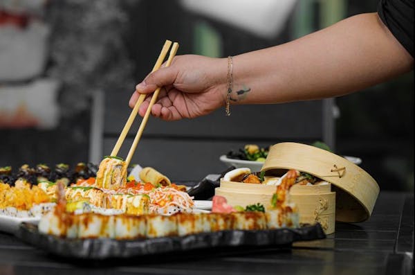 Image of a customer picking up sushi with chopsticks