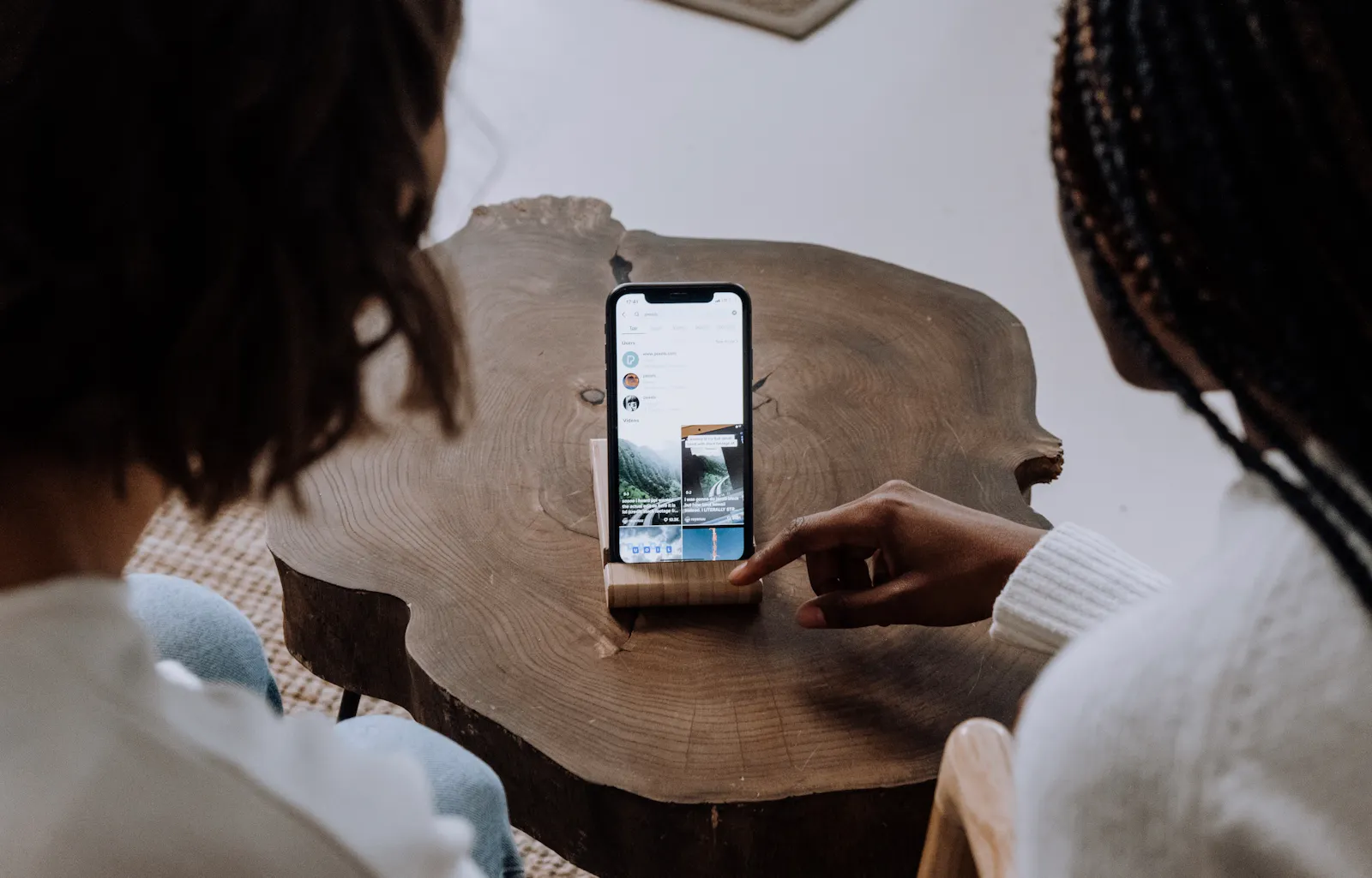 Image of two women scrolling through TikTok at a restaurant