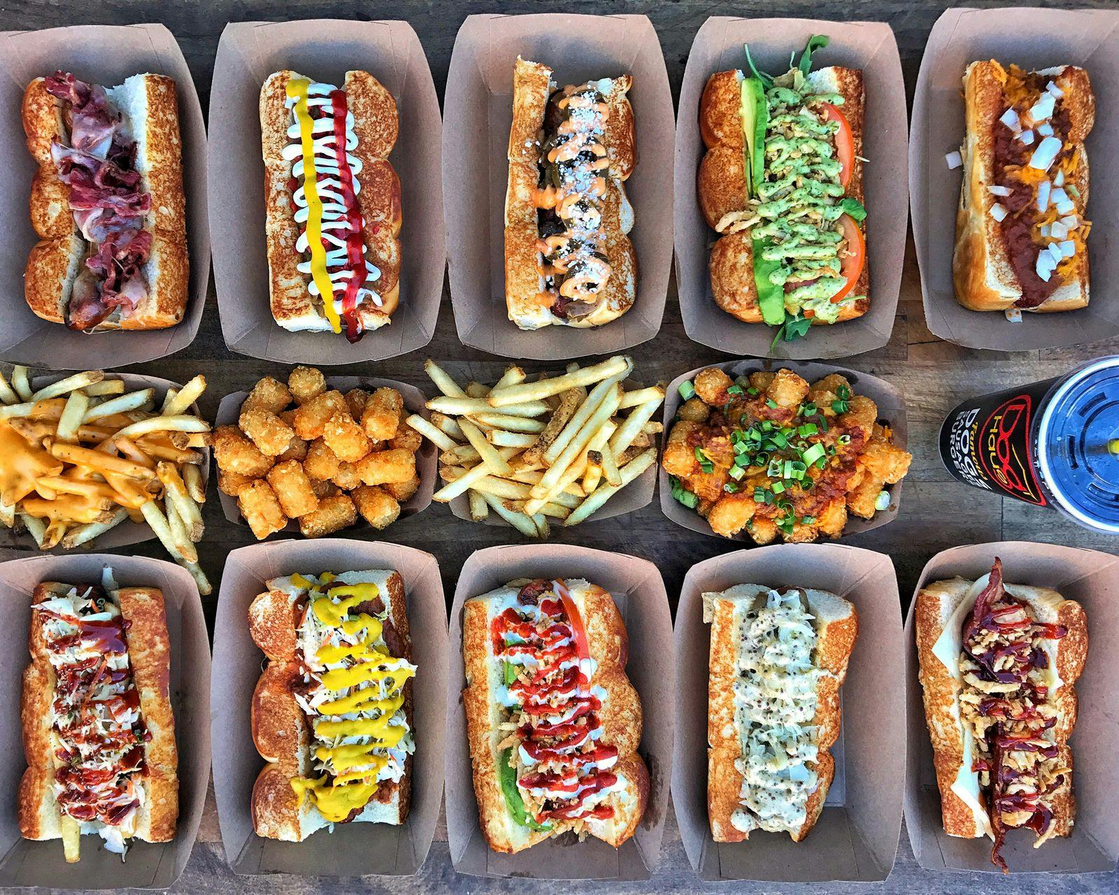 Image of 10 assorted Dog Haus hot dogs with french fries and tater tots in the middle