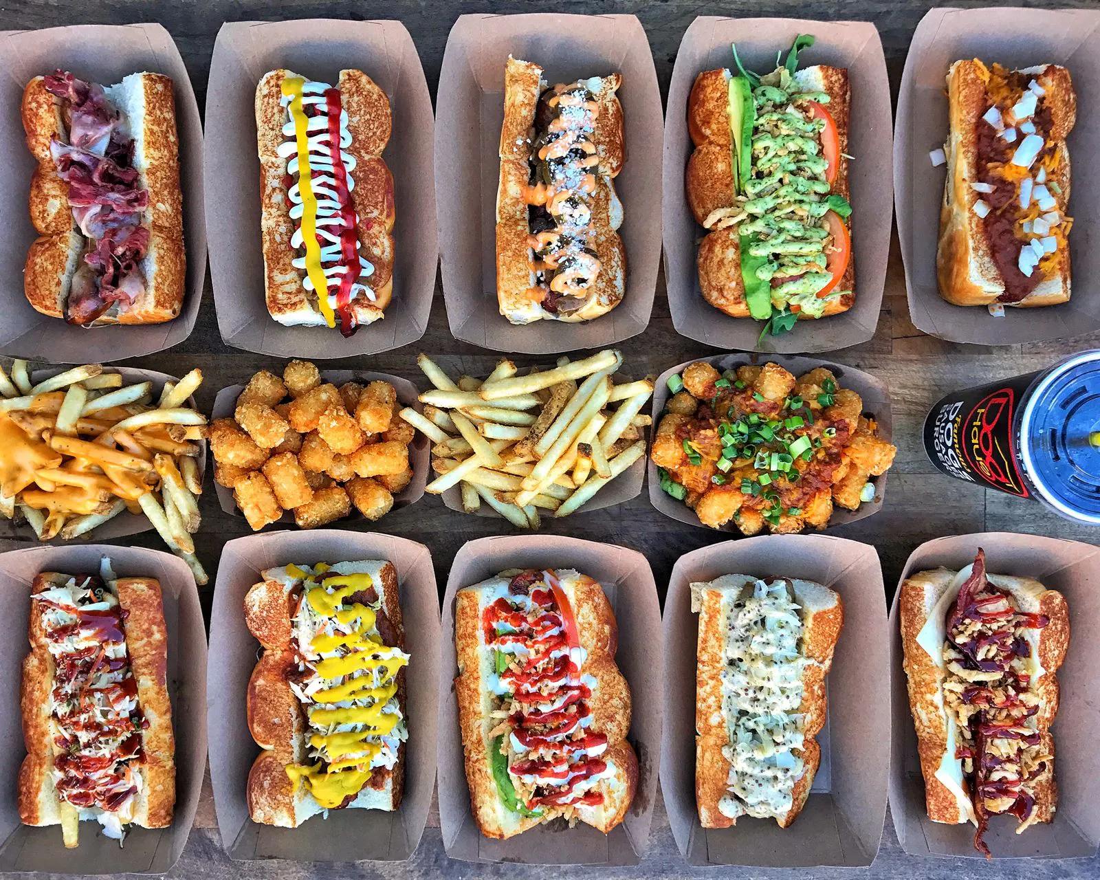 Image of 10 assorted Dog Haus hot dogs with french fries and tater tots in the middle
