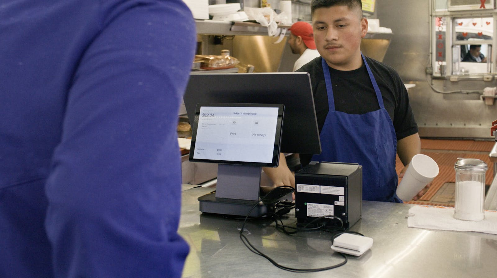 A staff member using Otter's Restaurant Operating System at Jim's Burgers.